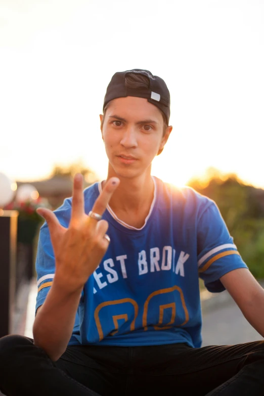 a person sitting with their hands up and making the peace sign