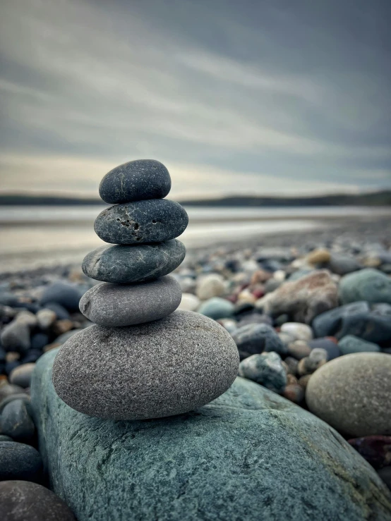 many stacked stones and boulders near the water