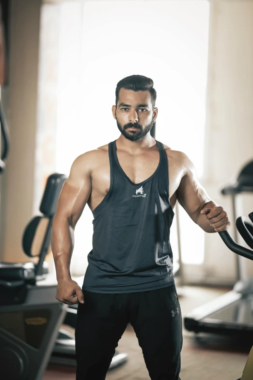 a man posing with a machine in a gym