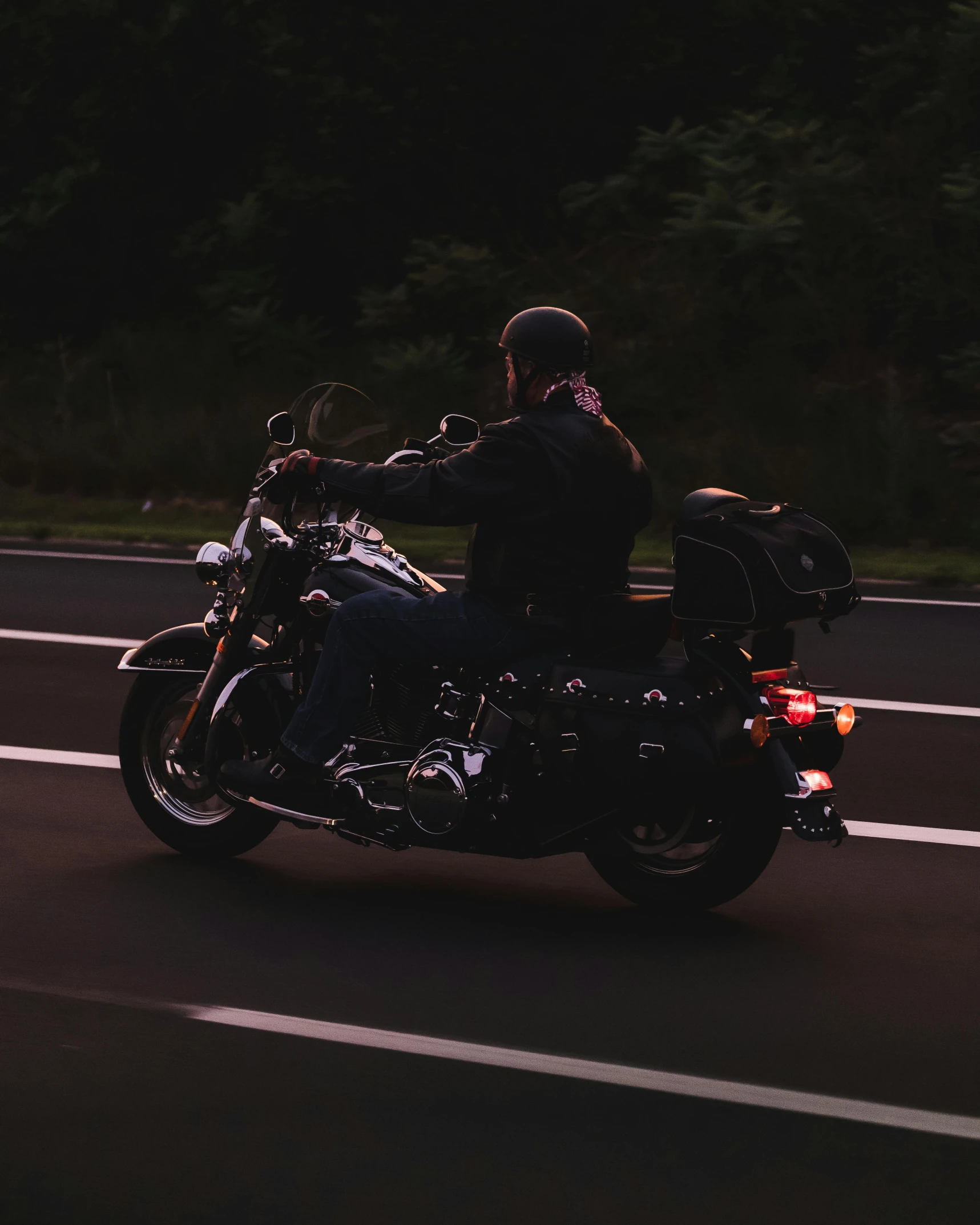 a man riding a motorcycle down the road