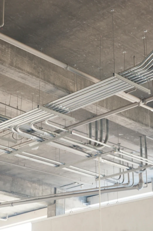 rows of metal pipes running under a suspended ceiling