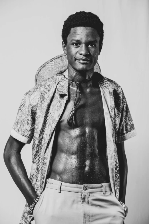 a shirtless man poses for a black and white portrait