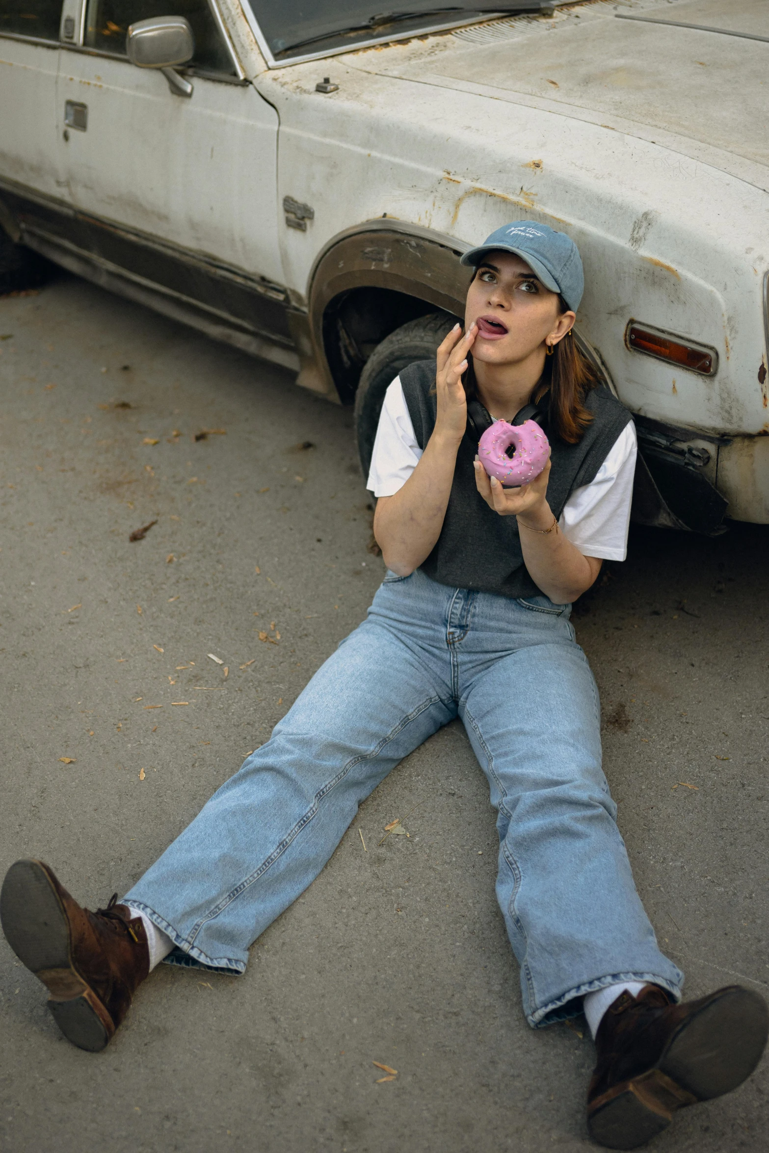 a woman sitting on the ground eating a donut