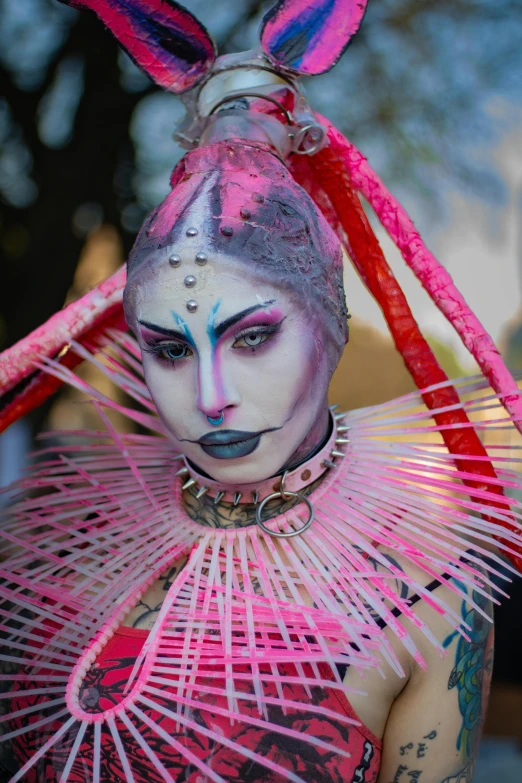 a woman with painted makeup holding some red and pink decorations