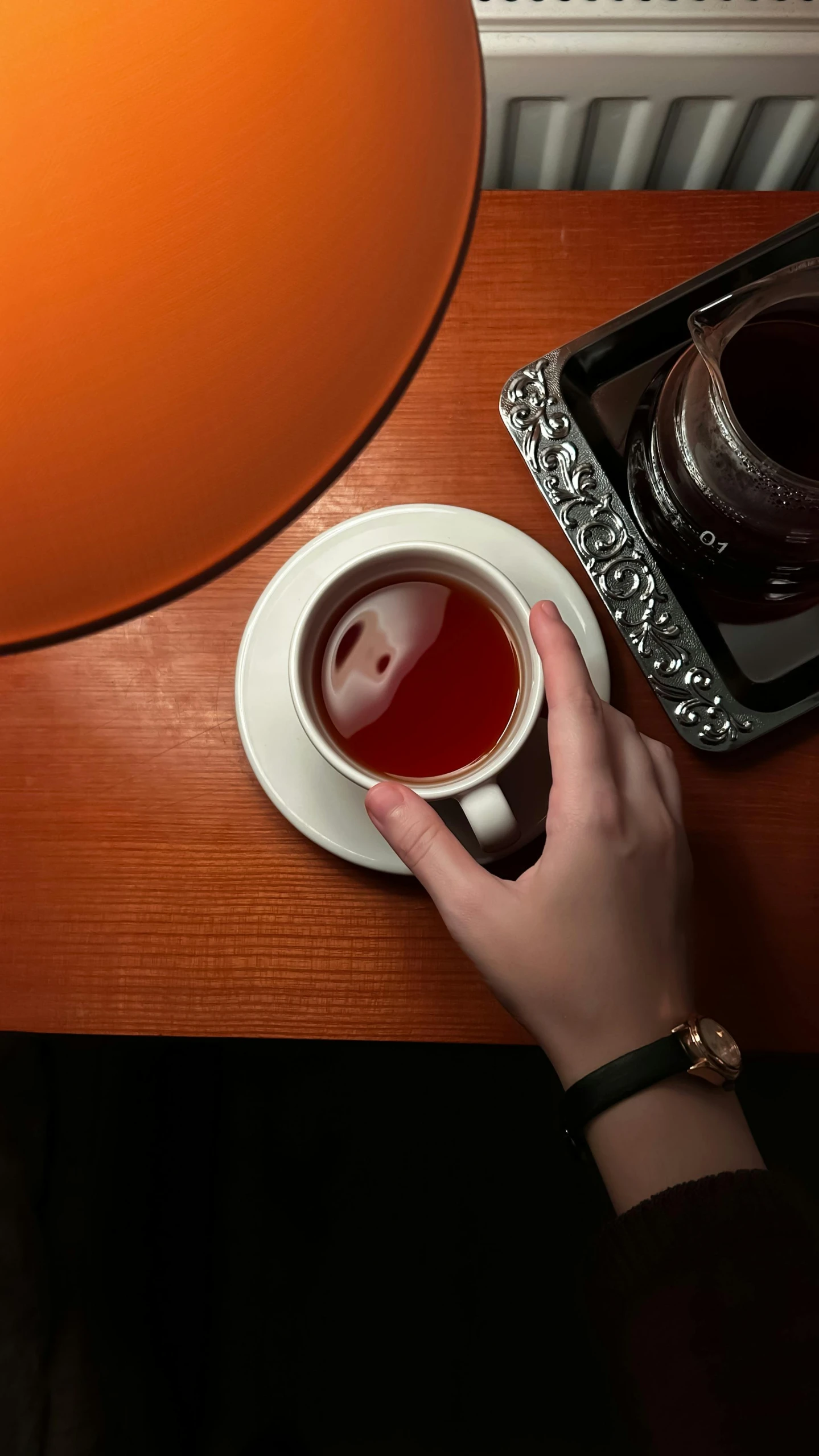 a person is holding a cup of tea and a tray