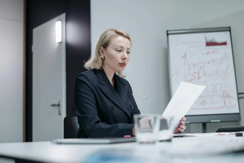 a woman sitting at a table with a paper