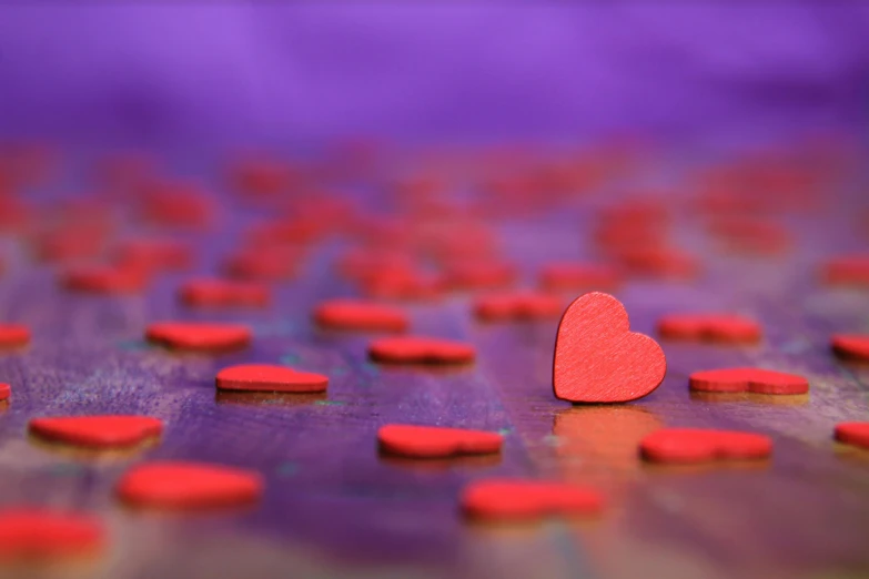 a lot of hearts on a table with one red heart