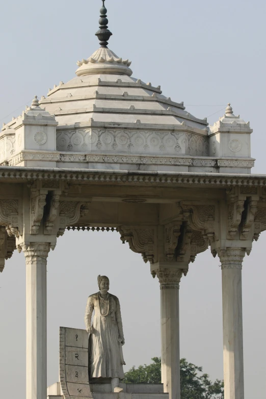 a statue in the middle of a gazebo in the day