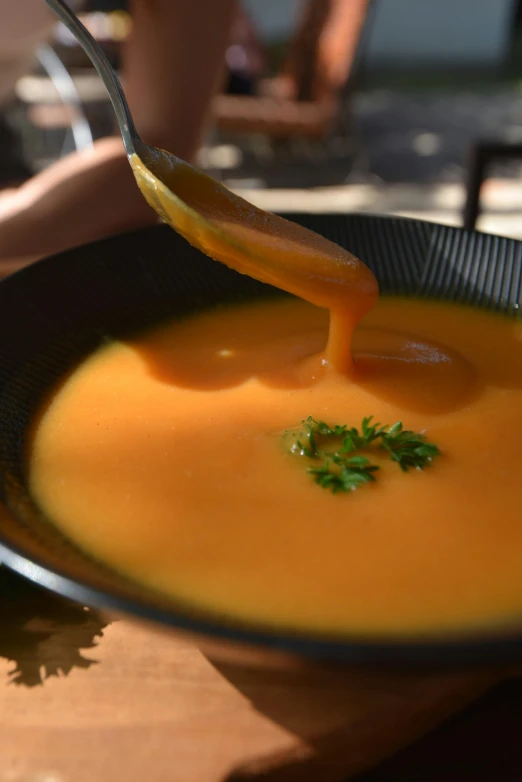 a spoon dipping some sauce into a bowl of food