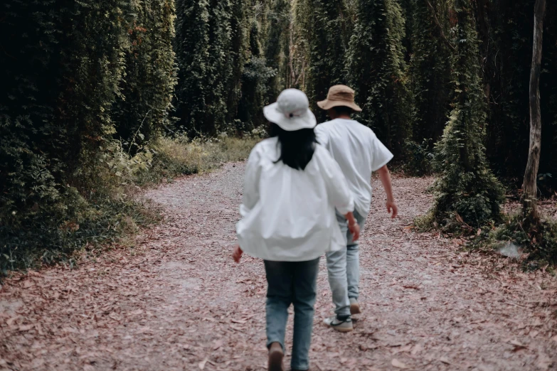 two people walking along a path on a cloudy day