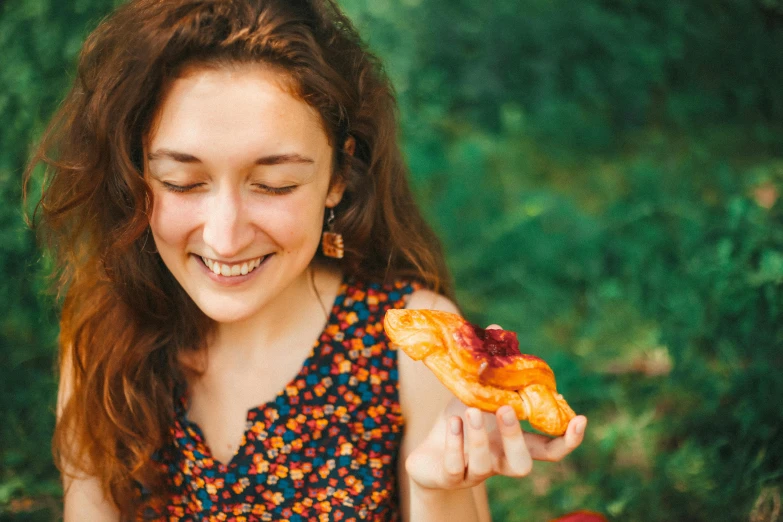 a woman holds out half a pizza