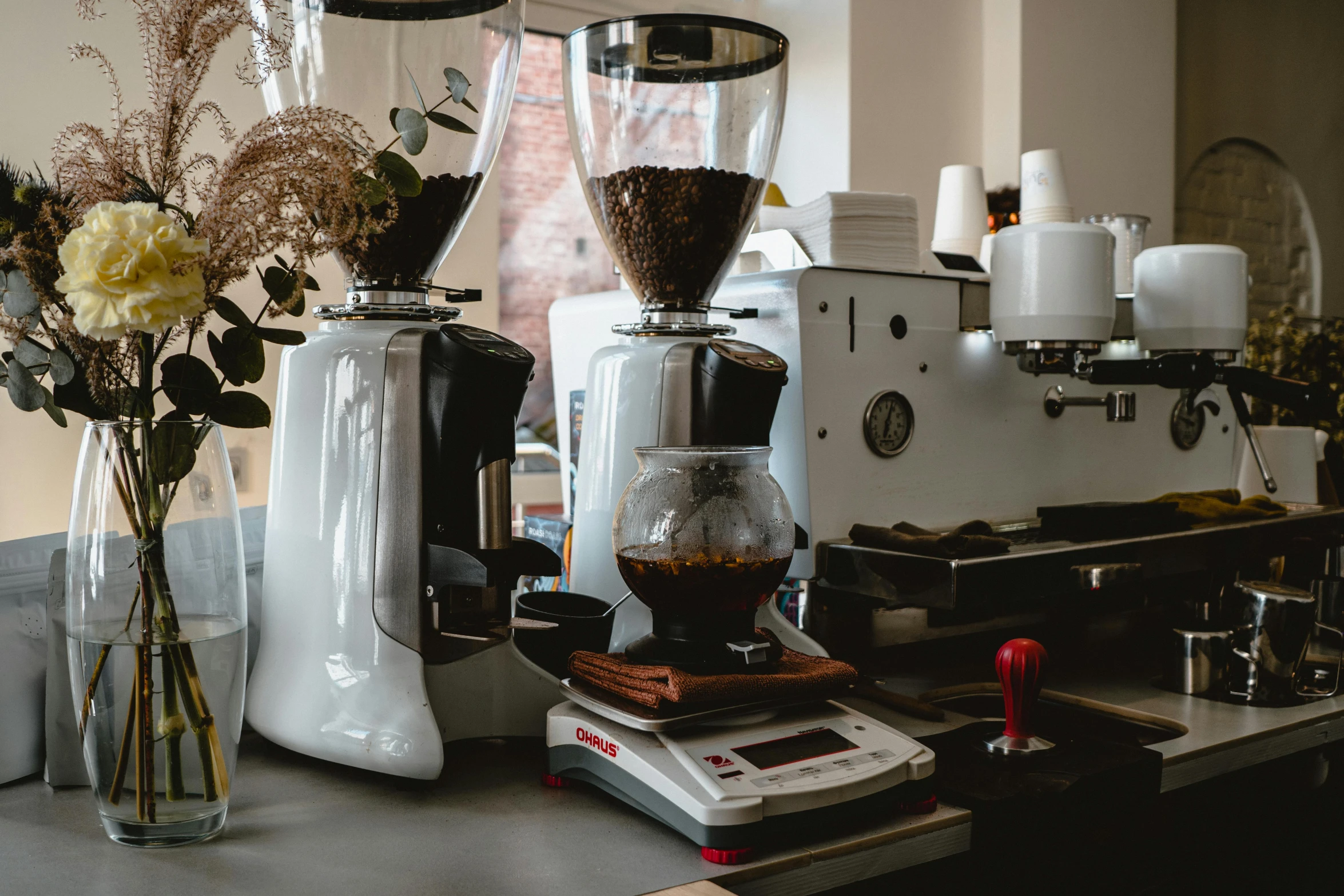 a coffee machine on a counter with flowers next to it