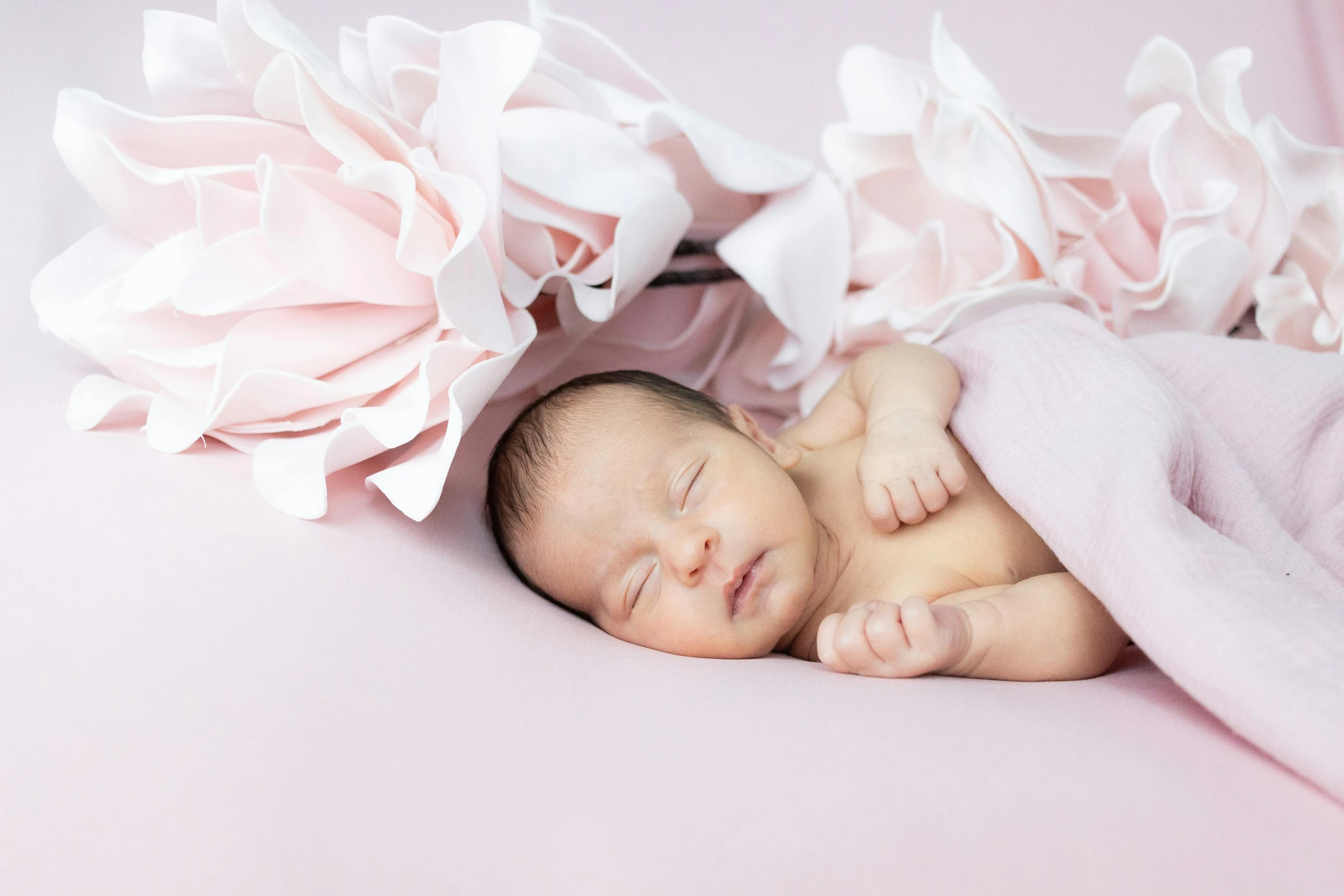 a baby is laying in a pink blanket