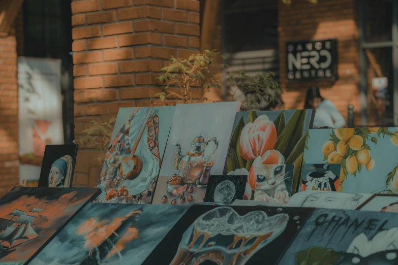 an assortment of colorful paintings in front of a brick building