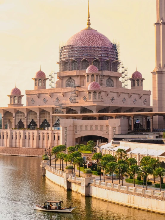 a large building by the water with a boat in front of it