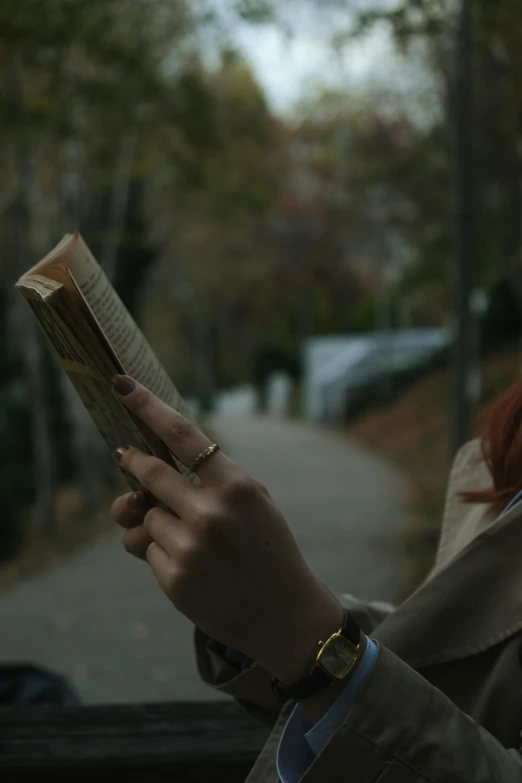 woman looking at book while sitting in a car