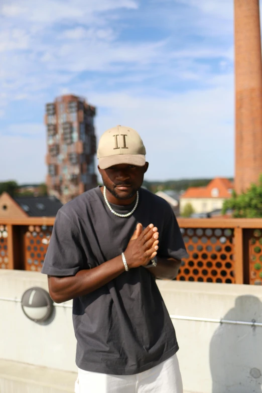 a man with his hands clasped near the top of a building