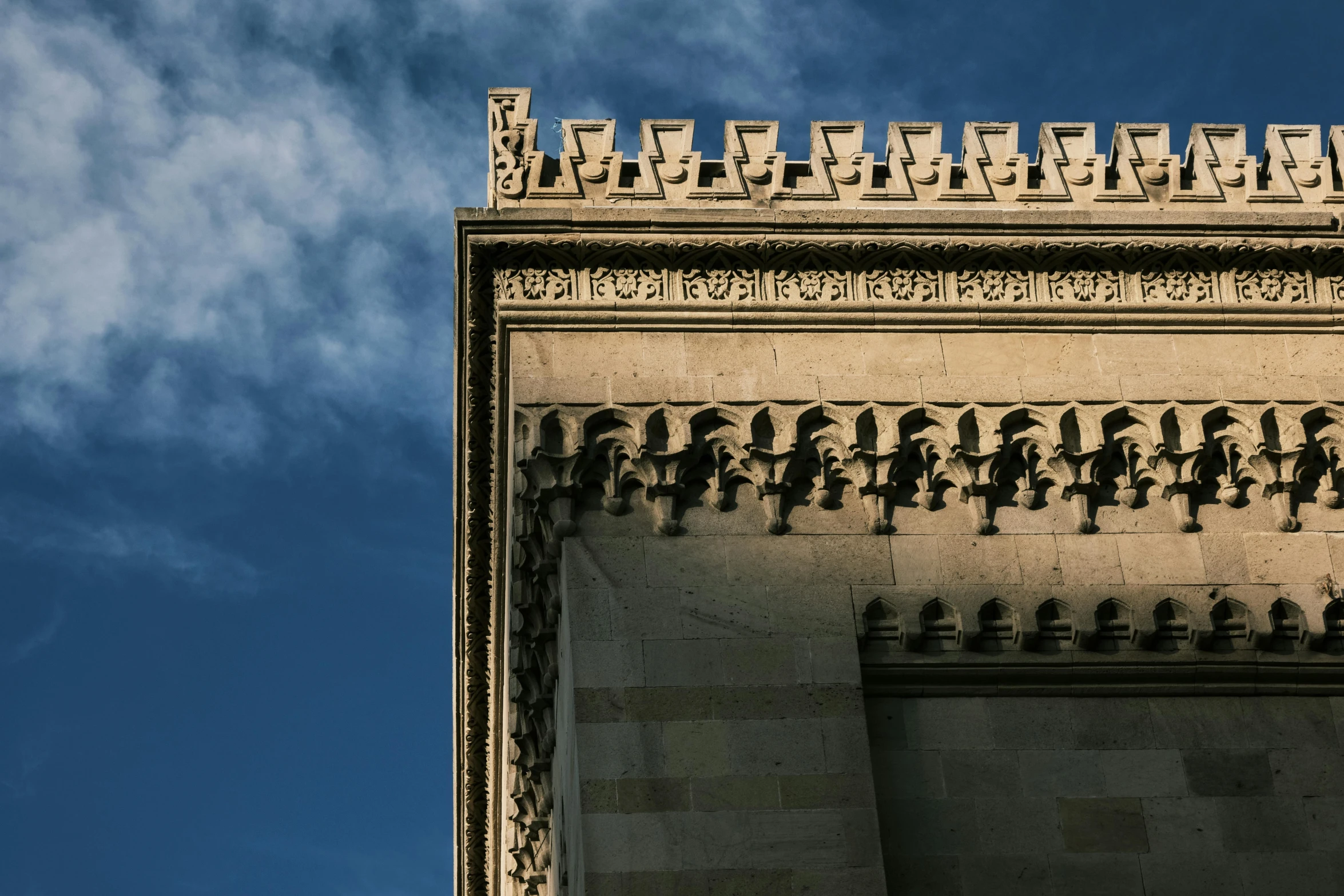 the tower top of an old building with birds and clouds