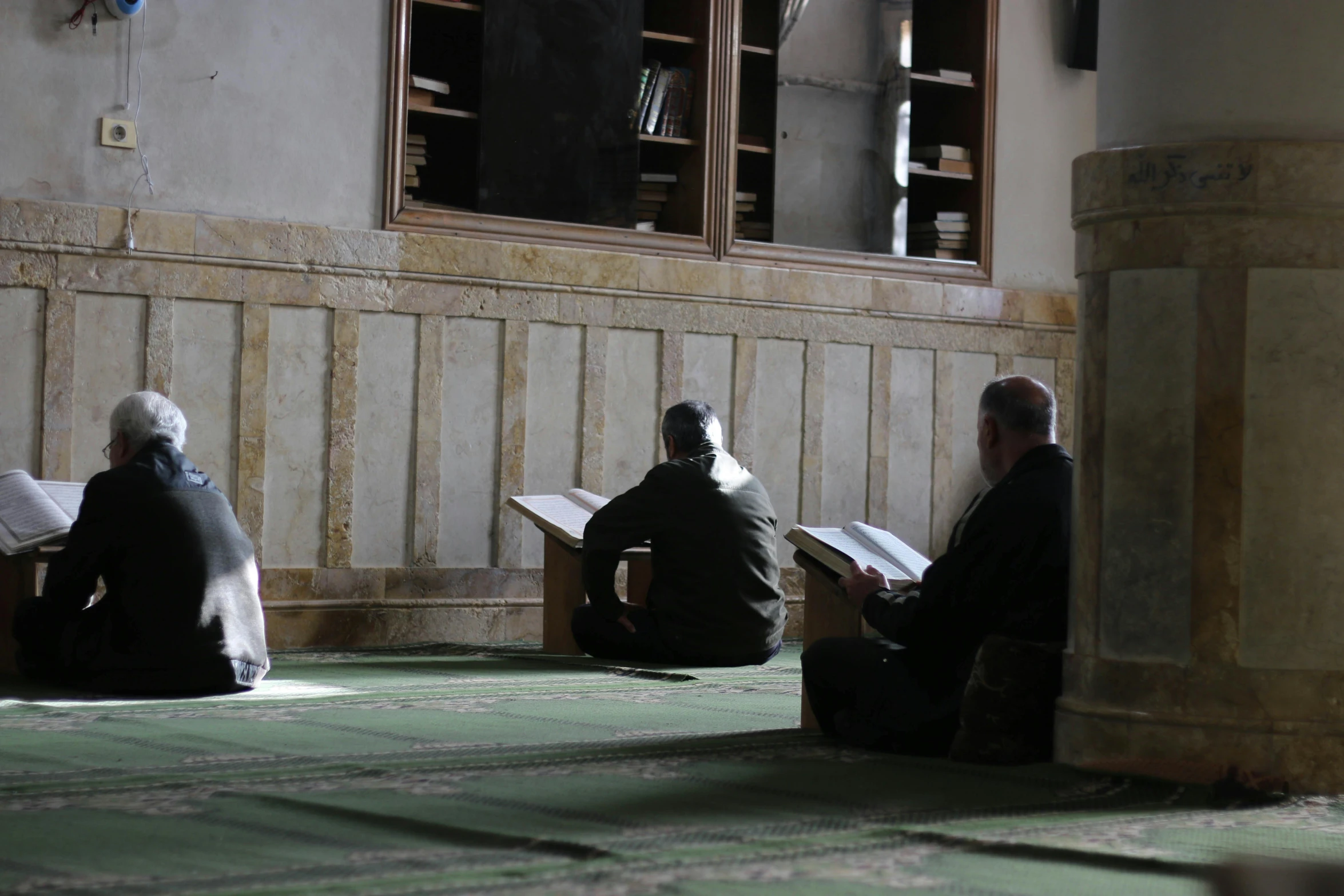 three men are sitting and reading their names