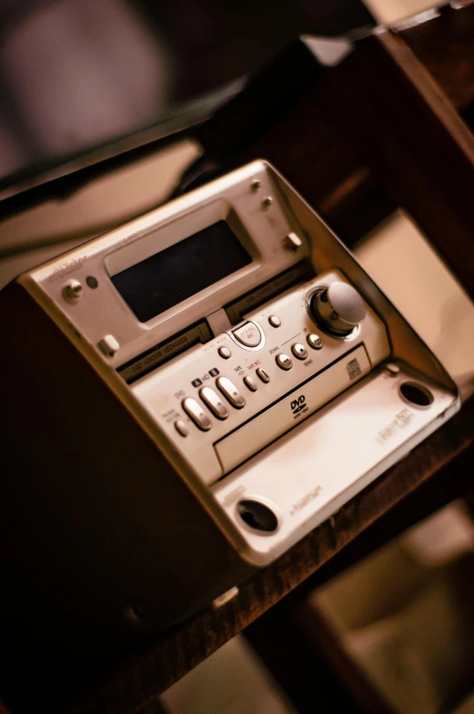 an old, broken audio player sits on a wooden table