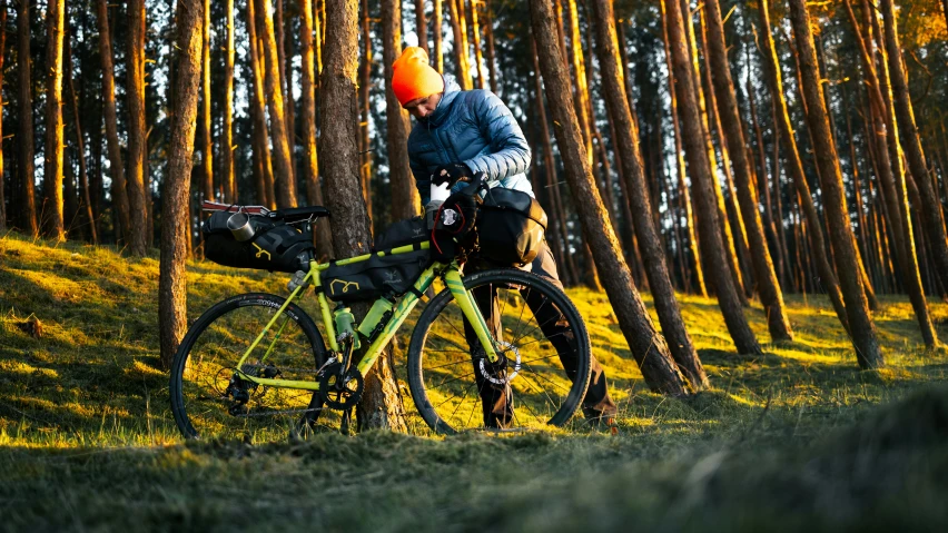 a woman riding a bike down a path past a forest