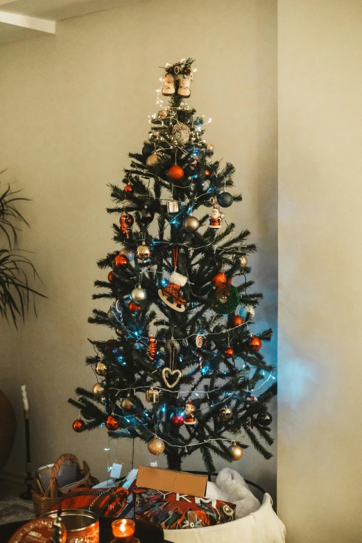 a tree with bright colored ornaments sits on the floor next to other items and decor