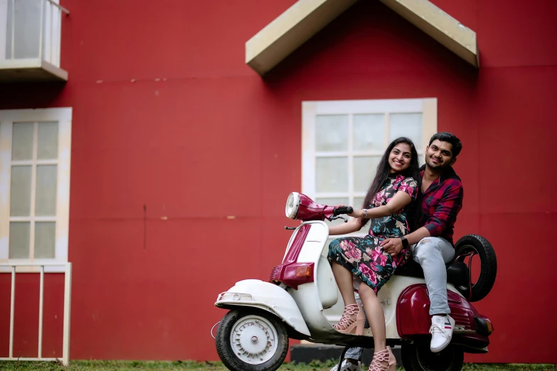 a man and woman are riding a scooter