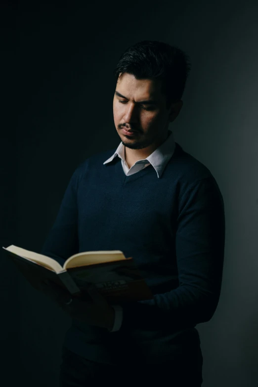 a man in a black shirt holding a book