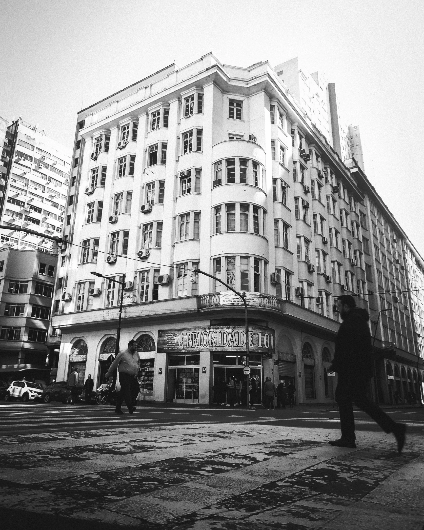 people walking and on the street in front of a large building