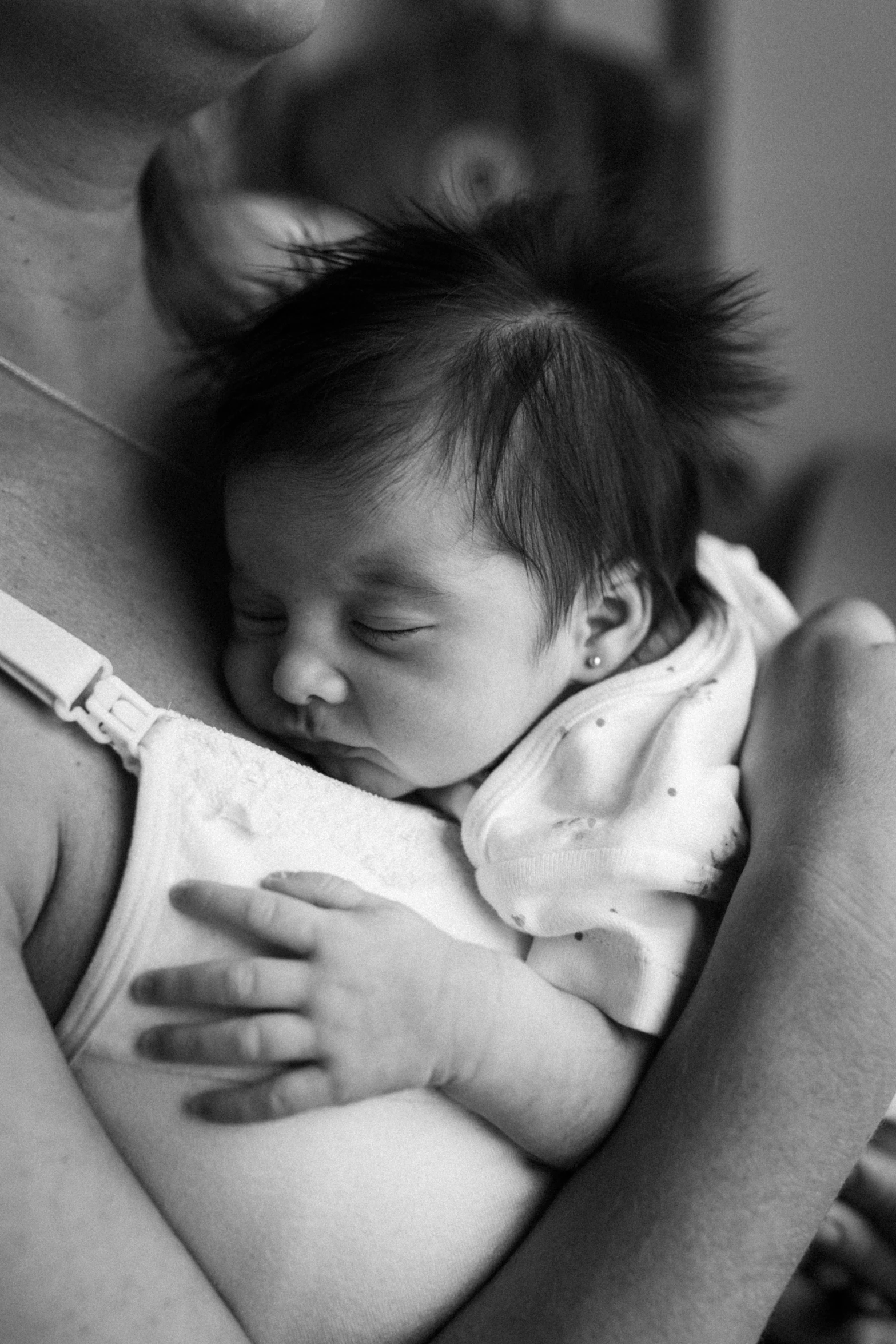 a woman holding a baby who is wrapped in a blanket