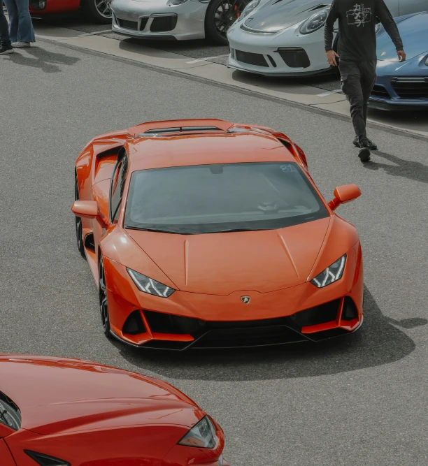 two orange sports cars parked next to each other