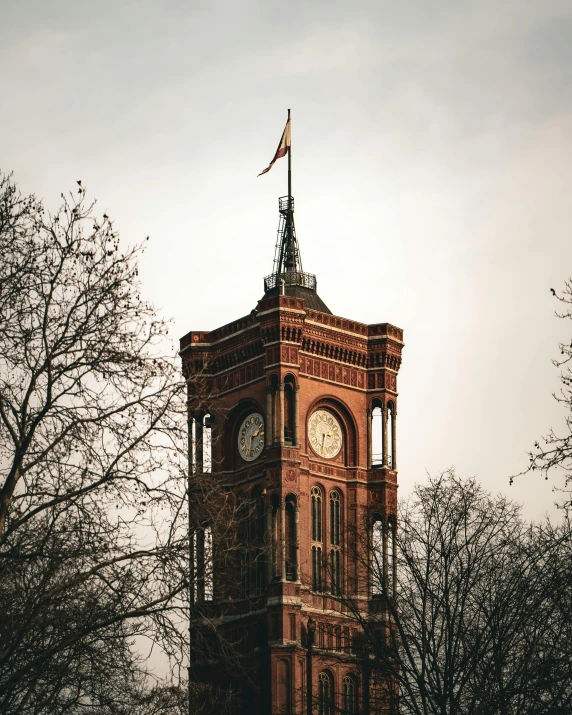 an old stone clock tower with a flag on top