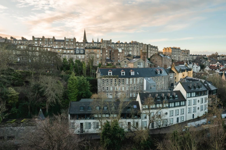 a city skyline shows old, cobblestone building with a steeple on top