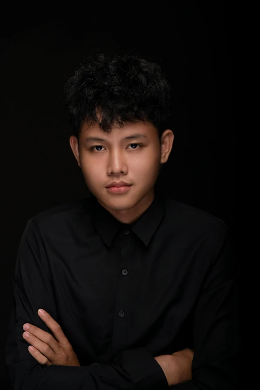 an asian boy posing for a picture wearing a black shirt