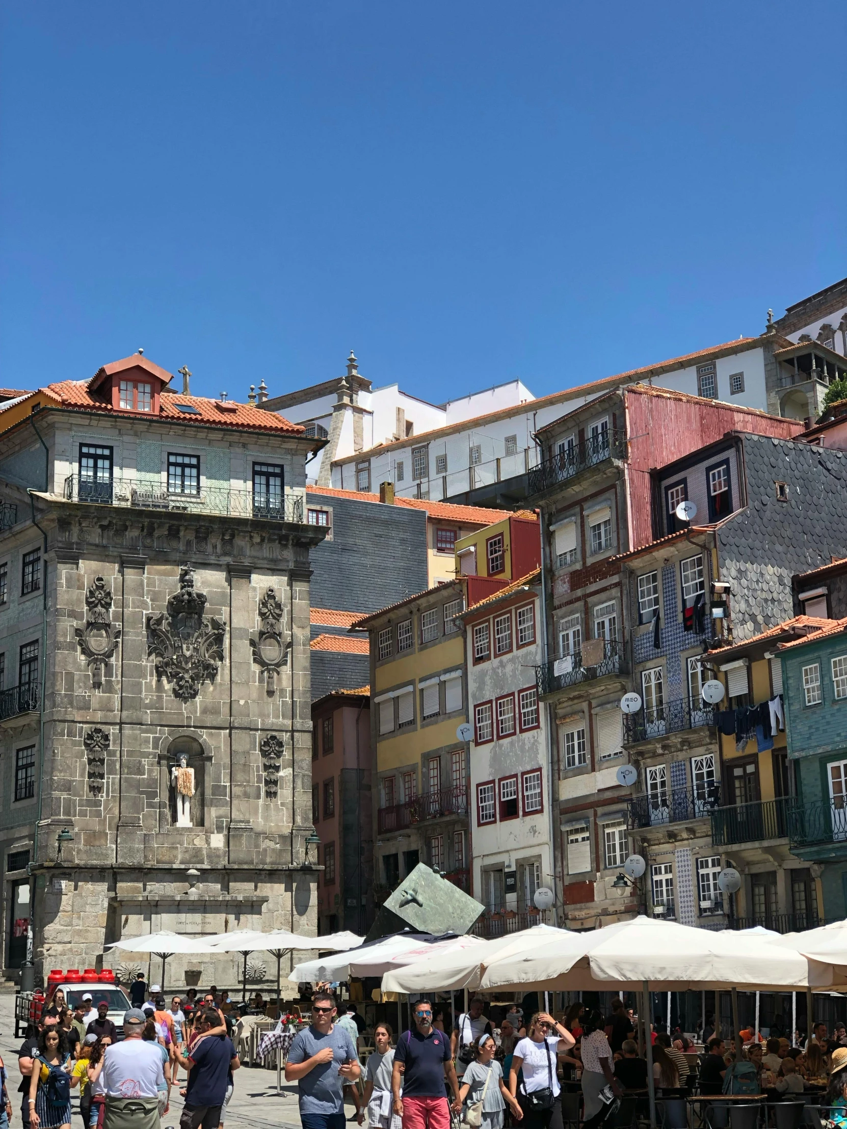 the old buildings are surrounded by white umbrellas