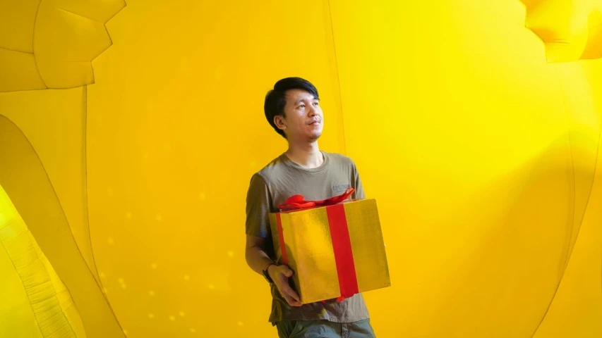 a man holds up his gift bag while looking in a wall