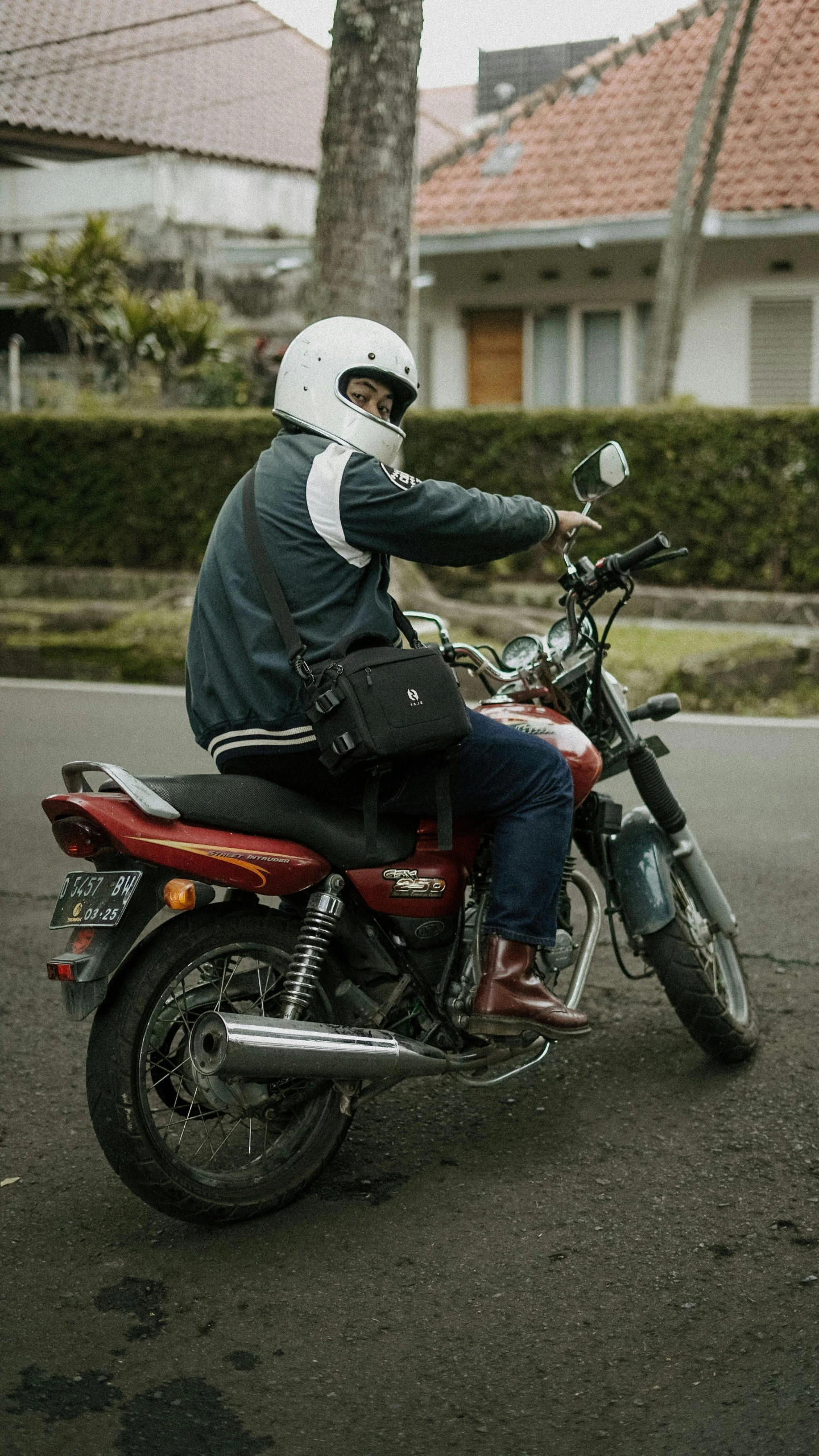 there is a man riding his motorbike down the street