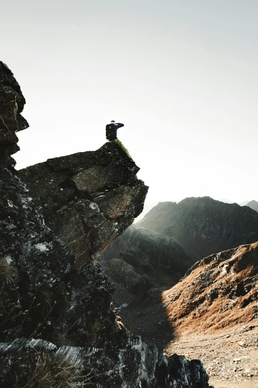 the person sits on a rock in the desert