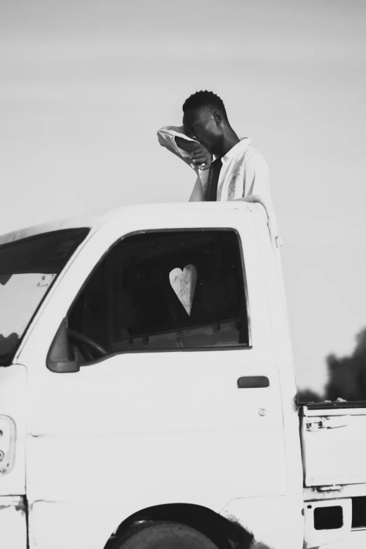 a man leaning on the back of a white truck