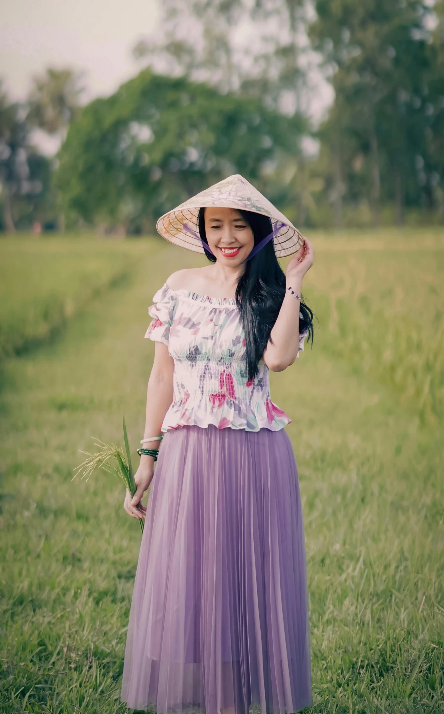 a woman wearing a purple skirt and a straw hat