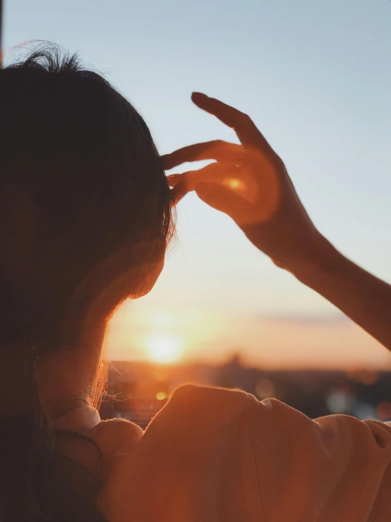 a woman holding her hands up in the air