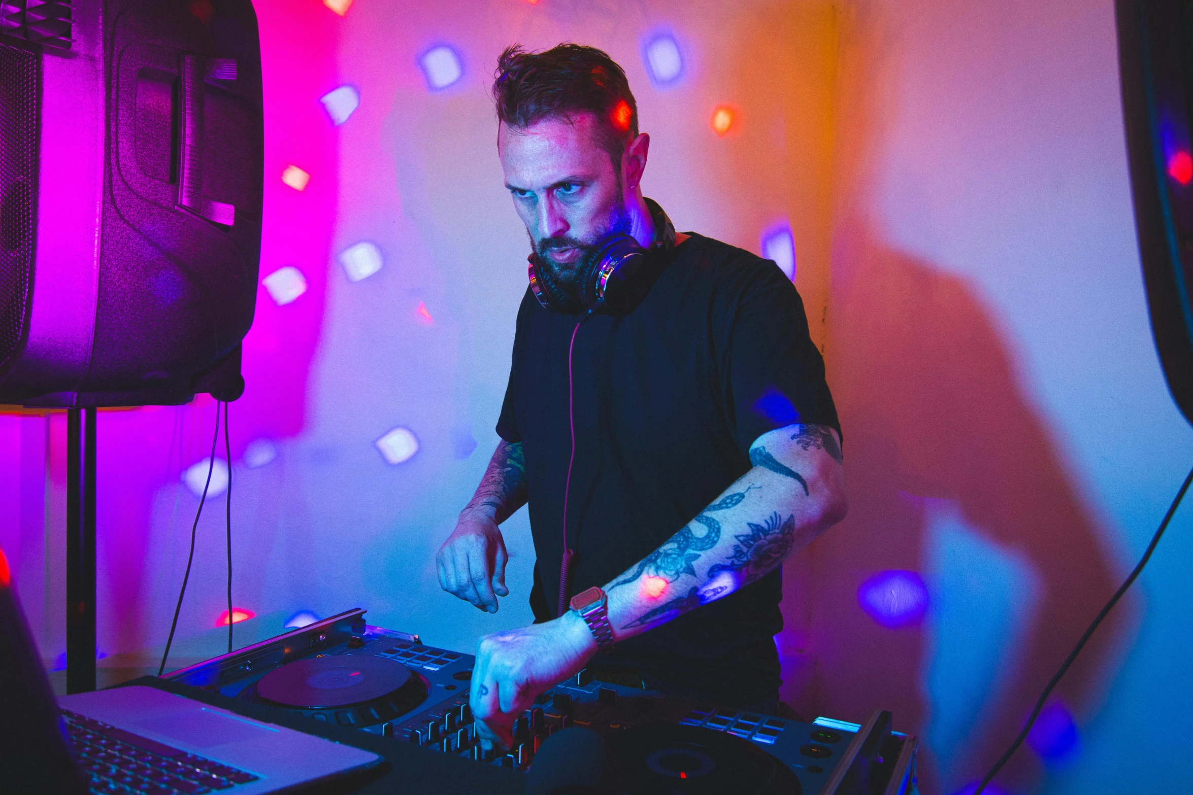 a man holding dj equipment playing music at a nightclub