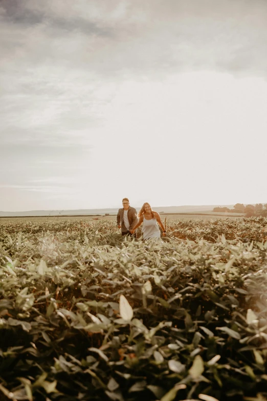 a man and woman walking through the grass