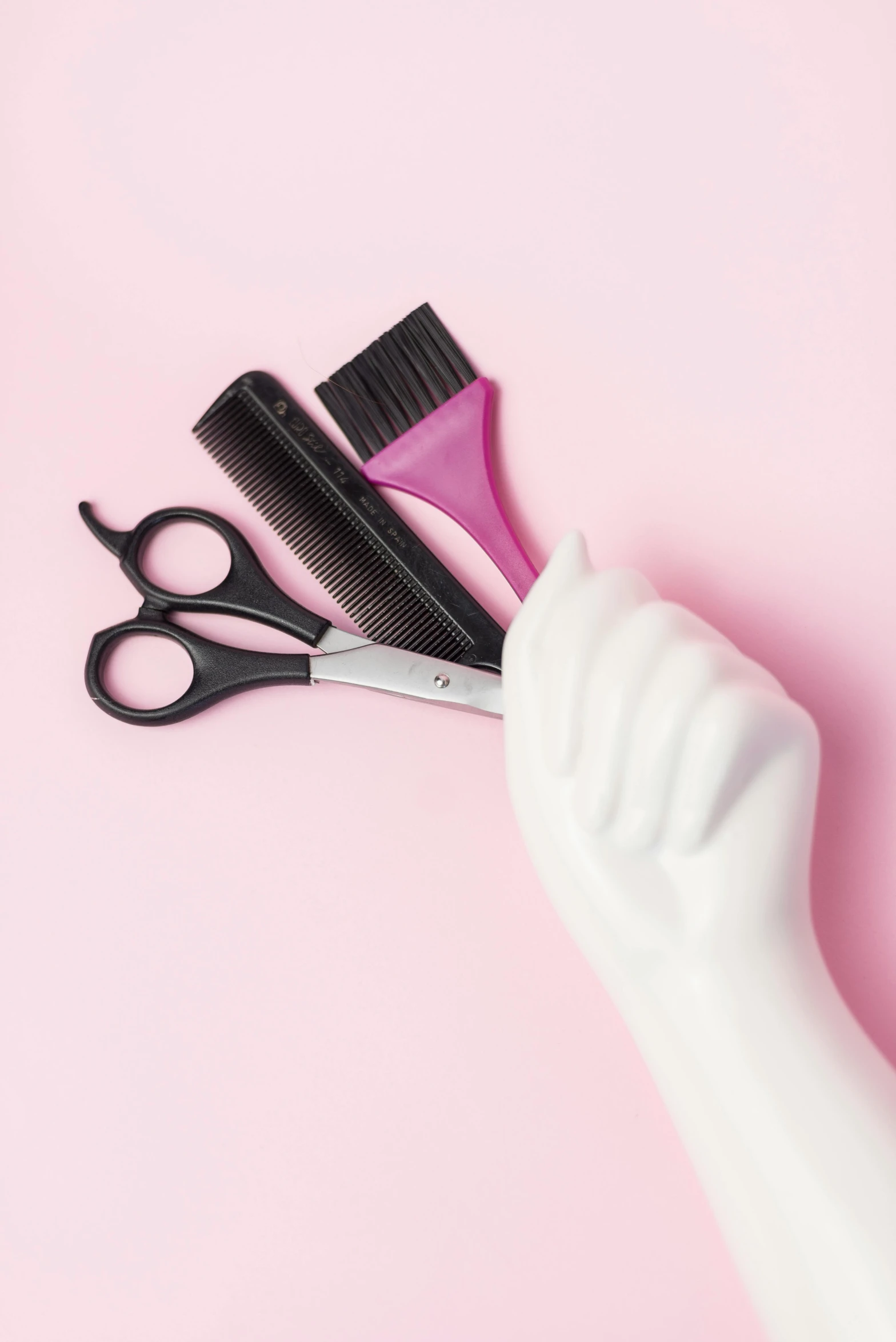 a brush and scissors lying on top of a white head