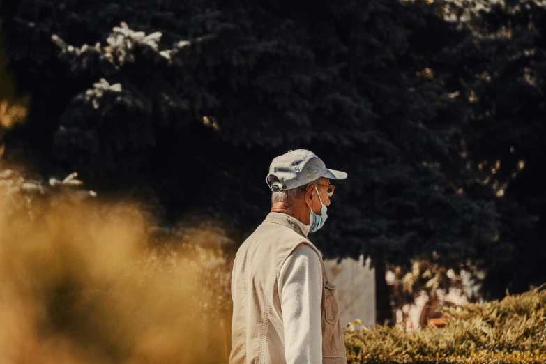 an older man wearing a face mask looking into the distance