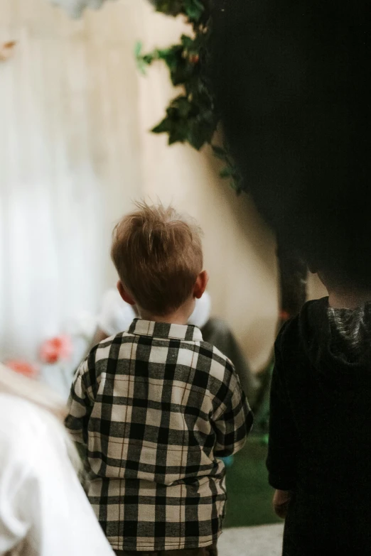 a boy stands in the foreground while he watches another child