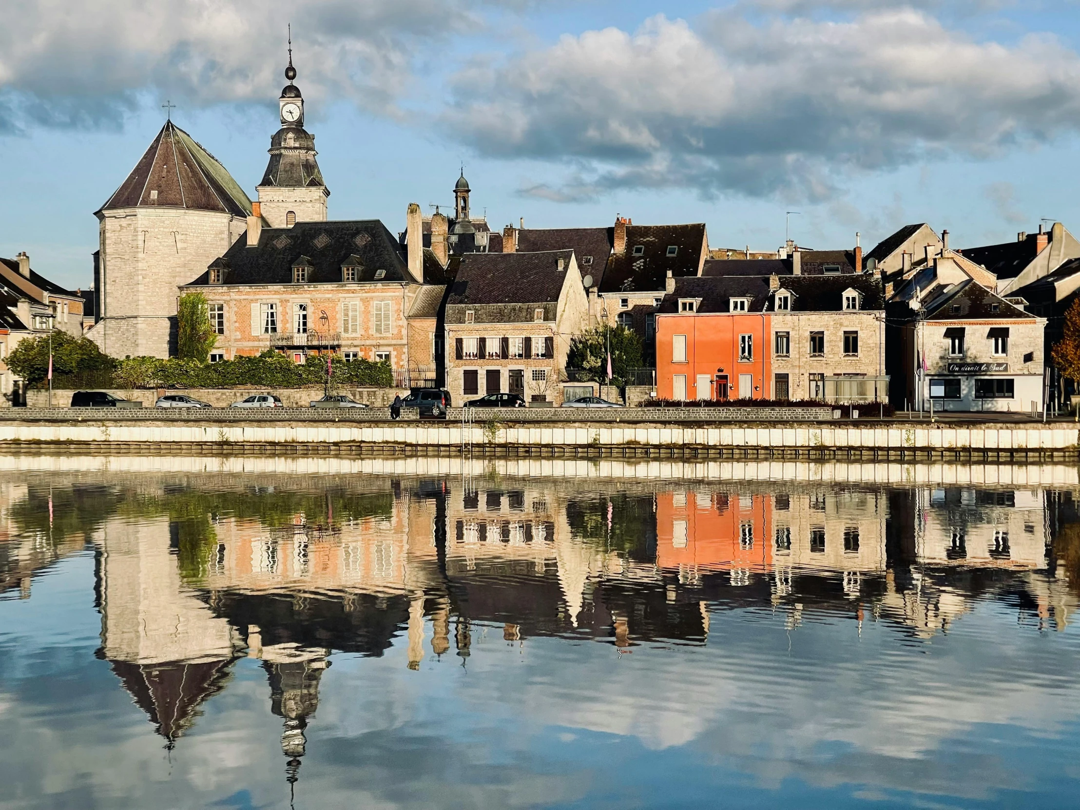 old, brick - built houses reflect in the calm water