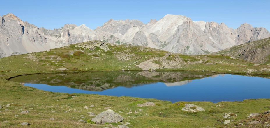 the large blue water is in the valley with mountains