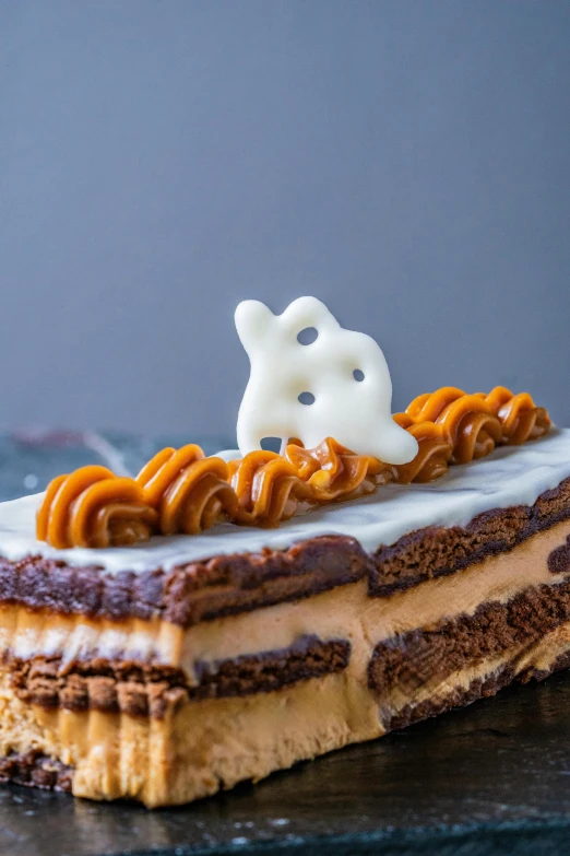 a white ghost in the shape of a pumpkin pie on top of some cake