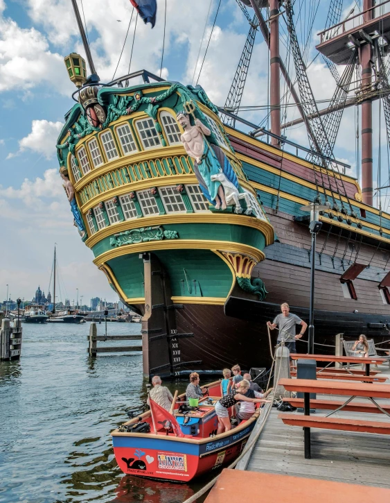 an elaborate ship with people in it sits on a dock